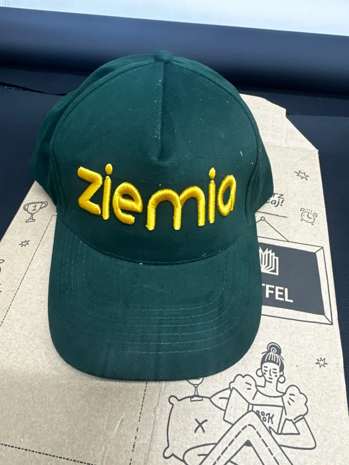 Zielona czapka firmowa z haftowanym logo wykonanym haftem komputerowym