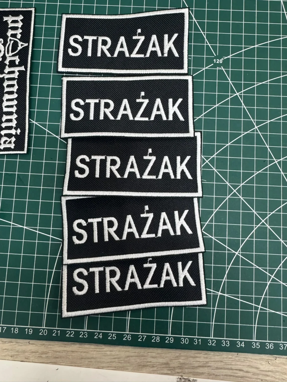 Czarne naszywki haftowane Strażak z białym napisem